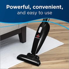 a black and silver vacuum sitting on top of a wooden floor next to a white rug