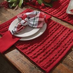 the table is set with red placemats and napkins, plates and utensils