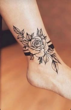 a woman's foot with a rose tattoo on it