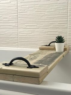 a potted plant sitting on top of a wooden shelf next to a bath tub