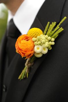 a boutonniere with an orange and yellow flower on it