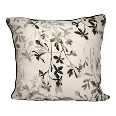 a white pillow with black and grey leaves on the front, sitting against a white background