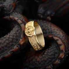 a gold ring sitting on top of a black snake skin