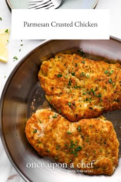 two fried chicken patties on a plate with lemon wedges and parmesan crusted chicken