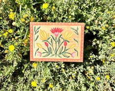 a painting on the side of a bush with yellow and red flowers in it's center