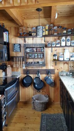 a kitchen with wooden walls and shelves filled with pots and pans