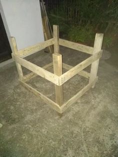 a wooden bed frame sitting on top of a cement floor