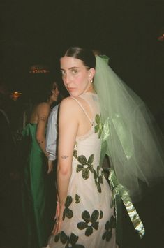 a woman in a wedding dress with a veil over her head and flowers on it