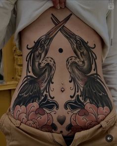 a woman's stomach with two birds and flowers on it