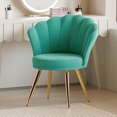 a green chair sitting in front of a mirror on top of a table next to a desk