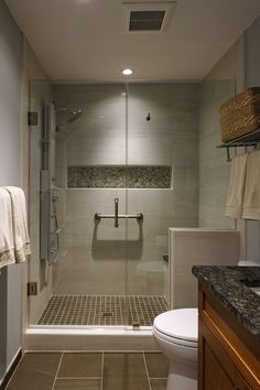 a bathroom with a walk in shower next to a toilet