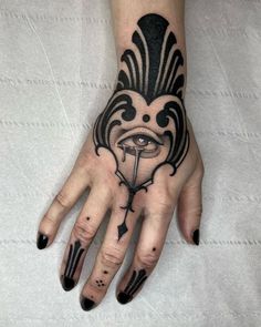 a woman's hand with a tattoo on it and an eye in the middle