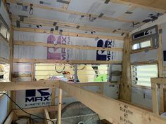 the inside of a small house with wood framing on the ceiling and windows above it