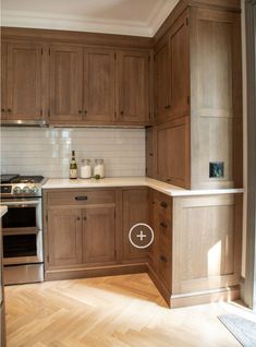 an image of a kitchen setting with wood cabinets and white tile backsplashes