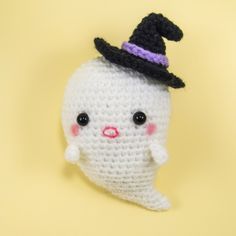 a crocheted doll with a black hat on it's head and nose