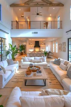 a living room filled with white furniture and lots of windows on top of the ceiling