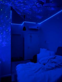 a bed in a room with blue lights on the ceiling and stars painted on the walls