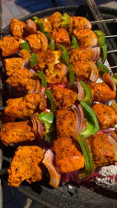 several skewers of meat and vegetables cooking on an outdoor bbq burner