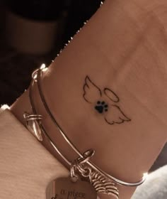 a close up of a person's wrist with a dog paw tattoo on it