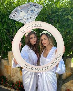 two beautiful women standing next to each other in front of a sign that says petrina delvocacia