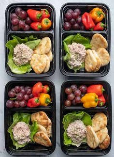 four black plastic containers filled with different types of vegetables and meat on top of lettuce