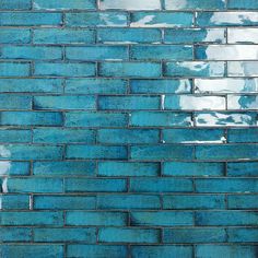 a blue brick wall with white clouds reflected in it