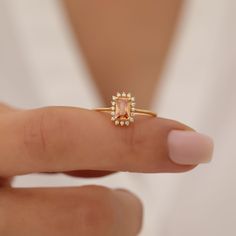 a close up of a person holding a ring with an orange stone in it's center