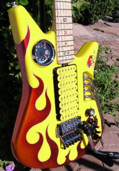 a yellow and red guitar with flames on it