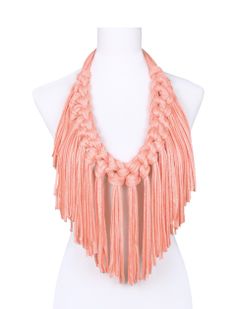 a mannequin wearing an orange necklace on top of a white dummyon with fringes