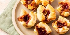 small pastries on a plate with cranberry sauce in the middle and other toppings