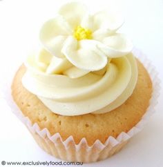 a cupcake with white frosting and a flower on top