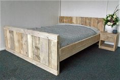 a bed made out of pallet wood in a room with carpeting and walls