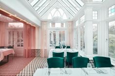 a dining room with tables and green chairs