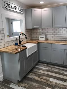 a kitchen with grey cabinets and wooden counter tops