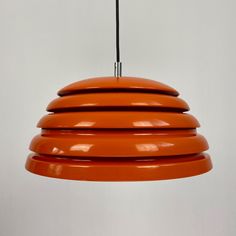 an orange pendant light hanging from a ceiling