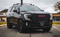 a black gmc suv parked in a parking lot