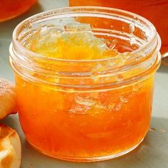 a jar filled with honey sitting next to some bread