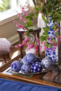 blue and white vases with pink flowers on a table