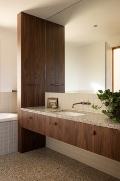 a bathroom with two sinks and wooden cabinets