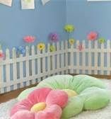 there is a dog bed in the room with flowers on the wall and behind it are three stuffed animals