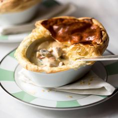 a close up of a bowl of food on a plate with a fork in it