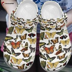 a pair of white shoes with colorful butterflies on the front and bottom, sitting in front of a person's hand