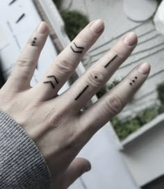 two fingers with the word love written on them, and one has an arrow tattoo on it