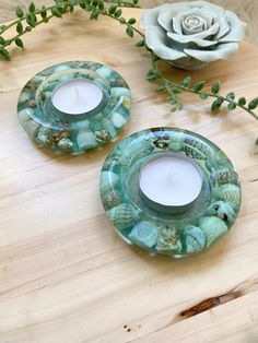 two tea light candles sitting on top of a wooden table