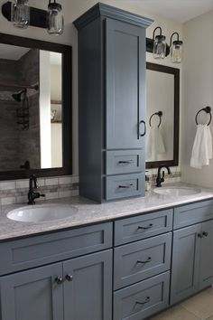 a bathroom with gray cabinets and marble counter tops