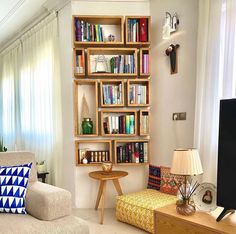 a living room filled with furniture and bookshelves next to a flat screen tv