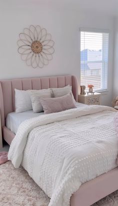 a bedroom with a pink bed and white comforter