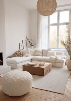 a living room filled with furniture and a fire place in front of a large window