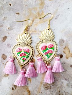 Beautiful handmade earrings delicately painted with a brush, on a light pink base and adorned with small hot pink roses and green leaves, adorned with light pink tassels, with several protective layers of jewelry varnish to protect the paint, quality and durability of the earrings. These earrings are inspired by Frida Khalo and hand painted with beautiful roses, part of our Mexican culture, they are the ideal accessory for any occasion, they will surely enhance your beauty since they are unique handcrafted pieces, the ideal gift for weddings, holidays or simply to make whoever gets it feel special, for its unique beauty. Features/ Product info Note: These earrings come in two sizes, large and small, please see attached photos. Size: Large The Main Material: Brass Color: Black and white - E