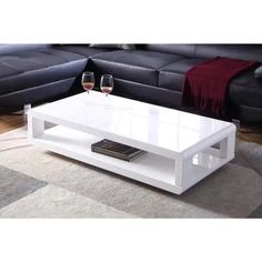 a white coffee table with two wine glasses on it